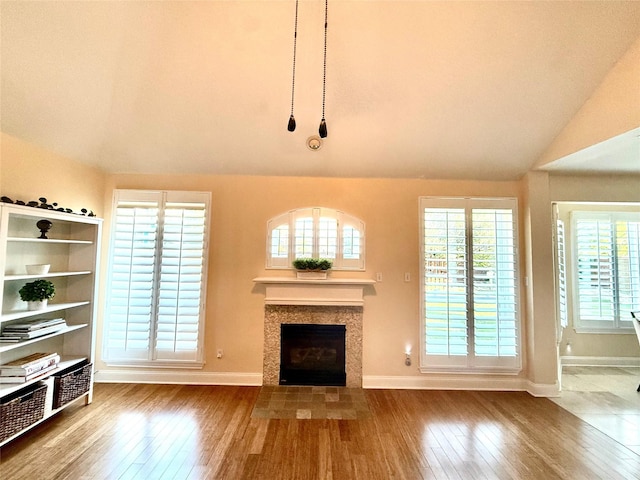 708 W Lonesome Dove Trl, Arlington, TX 76001 - unfurnished living room featuring hardwood / wood-style flooring, lofted ceiling, baseboards, and a tiled fireplace