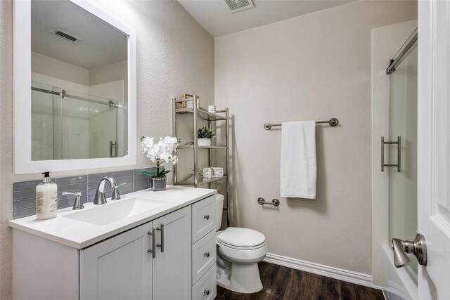 851 Sibyl Ln, Prosper, TX 75078 - bathroom with a shower with shower door, wood finished floors, toilet, vanity, and decorative backsplash