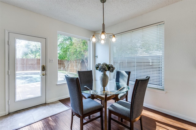 3717 Drew Dr, Frisco, TX 75035 - dining area with a chandelier, a textured ceiling, wood finished floors, and baseboards