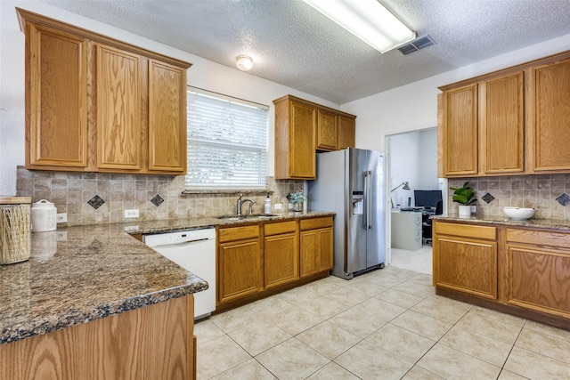 3717 Drew Dr, Frisco, TX 75035 - kitchen featuring dishwasher, high end refrigerator, a sink, brown cabinets, and a textured ceiling