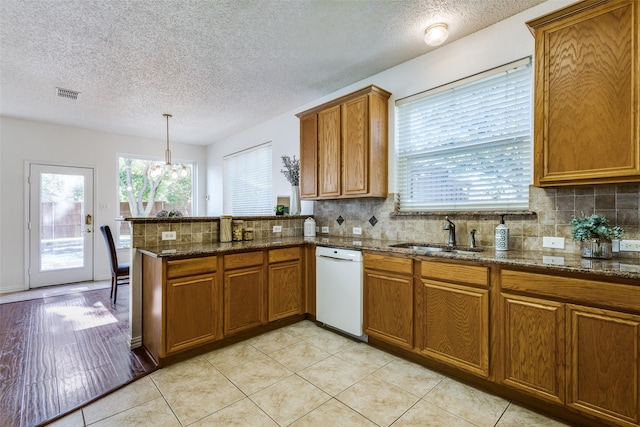 3717 Drew Dr, Frisco, TX 75035 - kitchen featuring dishwasher, brown cabinets, a peninsula, a sink, and a chandelier