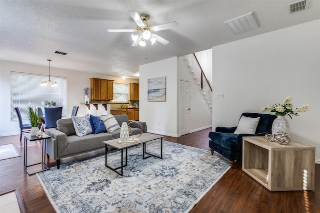 3717 Drew Dr, Frisco, TX 75035 - living room featuring stairs, a textured ceiling, a ceiling fan, baseboards, and dark wood-style floors