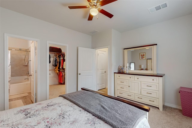 7448 Crossfire Trl, Fort Worth, TX 76112 - bedroom featuring a spacious closet, ensuite bath, light colored carpet, baseboards, and ceiling fan