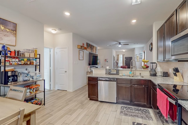 7448 Crossfire Trl, Fort Worth, TX 76112 - kitchen with stainless steel appliances, a sink, open floor plan, a peninsula, and a ceiling fan