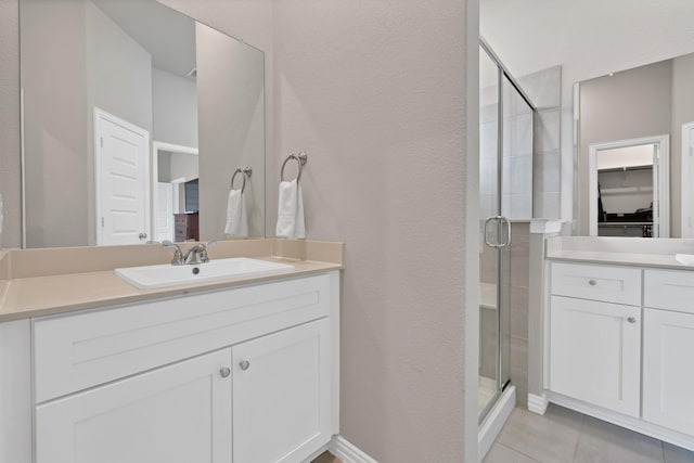 3935 Chesapeake Ln, Crandall, TX 75114 - bathroom featuring a shower stall, tile patterned floors, vanity, a walk in closet, and a textured wall