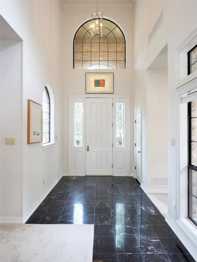 4541 Salerno Cir, Plano, TX 75093 - entryway featuring baseboards, a high ceiling, a chandelier, and ornamental molding