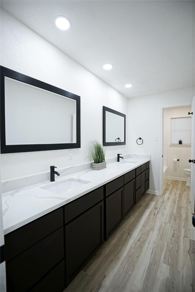 2409 Sunset Ln, Burleson, TX 76028 - full bathroom featuring toilet, wood finished floors, double vanity, baseboards, and a bathtub