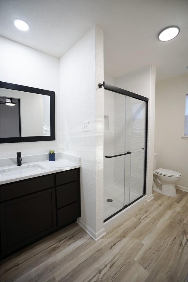 2409 Sunset Ln, Burleson, TX 76028 - full bathroom featuring wood finished floors, toilet, a shower stall, baseboards, and vanity