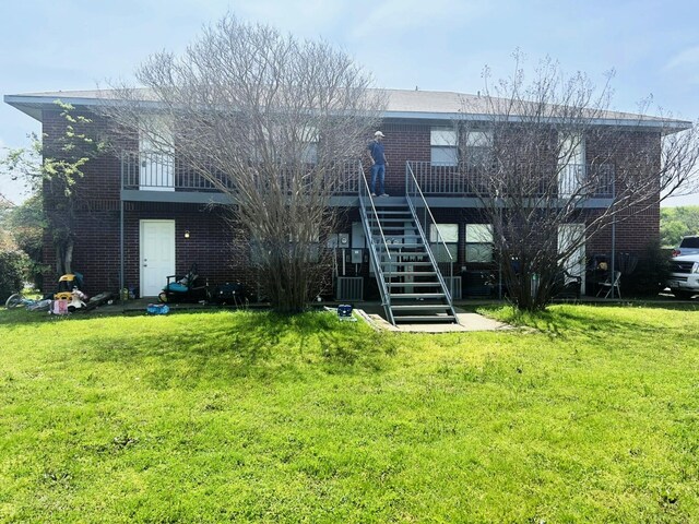 205 Joyce St, Weatherford, TX 76085 - back of house featuring stairway, brick siding, a yard, and a deck