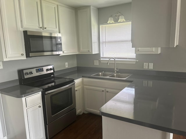205 Joyce St, Weatherford, TX 76085 - kitchen with appliances with stainless steel finishes, a sink, white cabinets, and dark wood-type flooring
