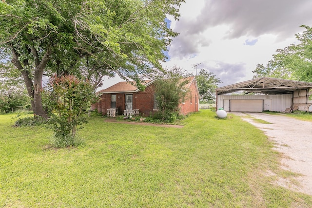 109 Honeysuckle, Paradise, TX 76073 - view of green lawn featuring driveway, an outbuilding, and a carport