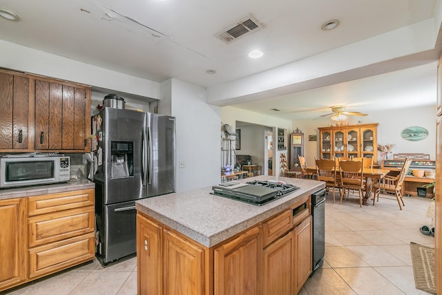 109 Honeysuckle, Paradise, TX 76073 - kitchen featuring stainless steel refrigerator with ice dispenser, light tile patterned floors, gas stovetop, a kitchen island, and white microwave