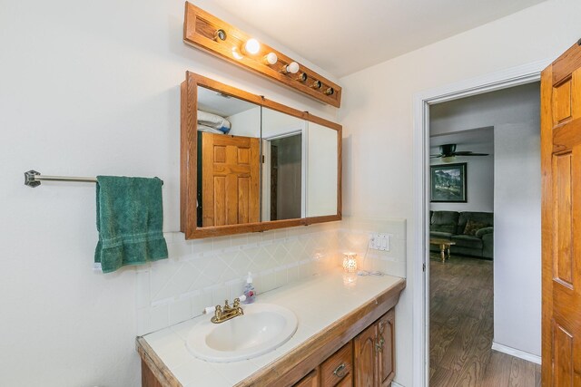 109 Honeysuckle, Paradise, TX 76073 - bathroom with vanity, wood finished floors, decorative backsplash, and ceiling fan