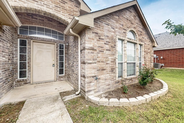 232 Cotton Wood Ct, Rockwall, TX 75032 - doorway to property with a lawn, brick siding, and central AC