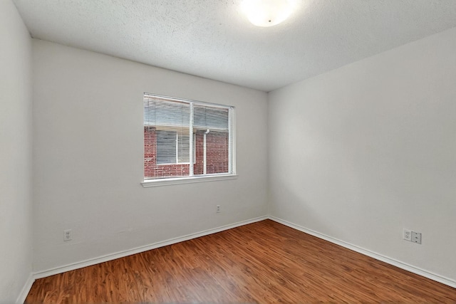 232 Cotton Wood Ct, Rockwall, TX 75032 - empty room with wood finished floors, baseboards, and a textured ceiling