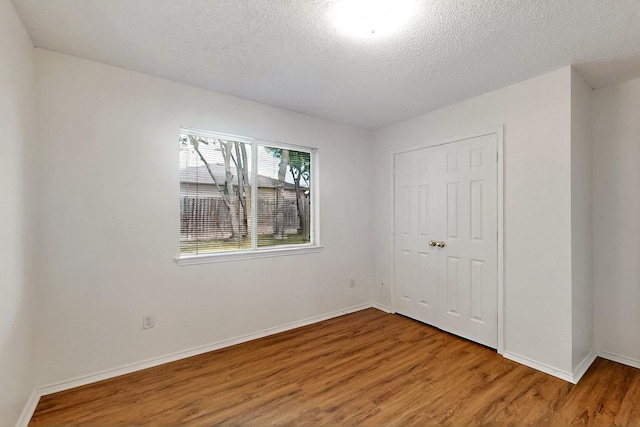 232 Cotton Wood Ct, Rockwall, TX 75032 - unfurnished bedroom featuring wood finished floors, baseboards, and a textured ceiling