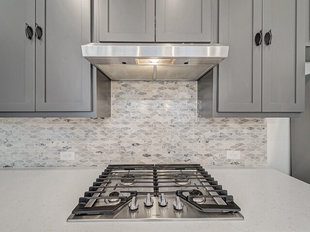 240 Harper St, Irving, TX 75063 - kitchen with stainless steel gas cooktop, under cabinet range hood, light countertops, tasteful backsplash, and gray cabinets