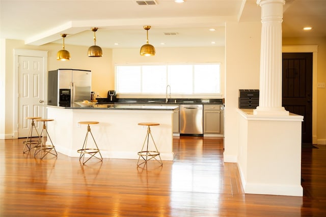 6318 White Oaks Ln, Frisco, TX 75035 - kitchen featuring appliances with stainless steel finishes, decorative columns, a sink, wood finished floors, and recessed lighting