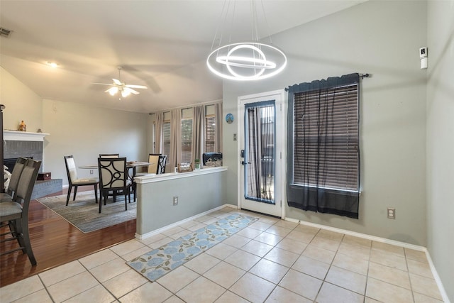 809 Fox Run Trl, Saginaw, TX 76179 - dining room featuring tile patterned flooring, a ceiling fan, baseboards, a chandelier, and a brick fireplace