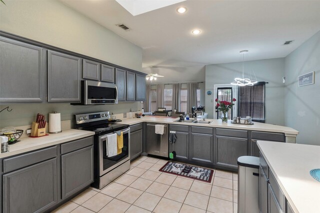 809 Fox Run Trl, Saginaw, TX 76179 - kitchen with appliances with stainless steel finishes, a sink, a peninsula, light tile patterned flooring, and light countertops
