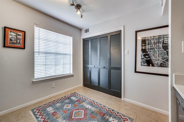 7640 W Greenway Blvd Unit 8L, Dallas, TX 75209 - bedroom with light tile patterned flooring, a closet, and baseboards