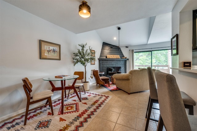 7640 W Greenway Blvd Unit 8L, Dallas, TX 75209 - dining room with light tile patterned floors, a brick fireplace, and lofted ceiling