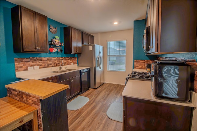 1141 Avalon Dr, Crandall, TX 75114 - kitchen with appliances with stainless steel finishes, a sink, backsplash, light wood finished floors, and light countertops