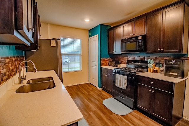 1141 Avalon Dr, Crandall, TX 75114 - kitchen featuring black appliances, a sink, dark brown cabinetry, light countertops, and tasteful backsplash