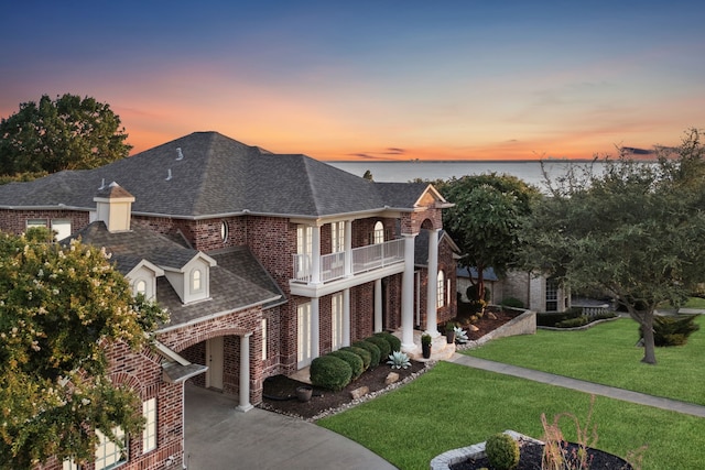 121 Lafayette Lndg, Heath, TX 75032 - view of front facade featuring a balcony, brick siding, roof with shingles, a front yard, and driveway