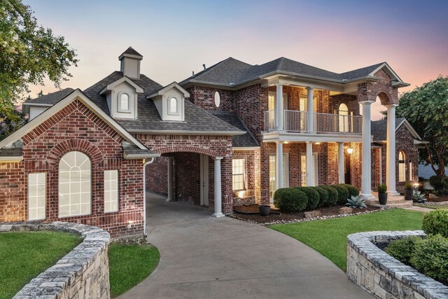 121 Lafayette Lndg, Heath, TX 75032 - view of front of property featuring a balcony, brick siding, driveway, a shingled roof, and a yard