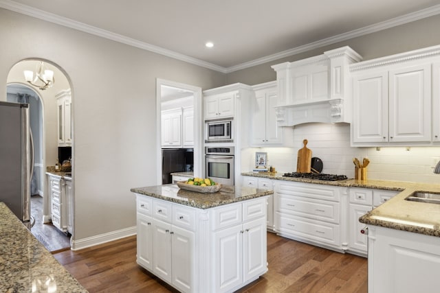 121 Lafayette Lndg, Heath, TX 75032 - kitchen featuring appliances with stainless steel finishes, dark wood-style flooring, ornamental molding, tasteful backsplash, and white cabinetry