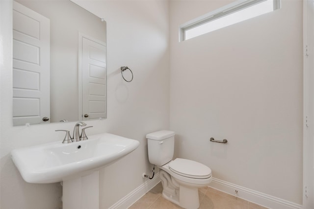 7104 Manhattan Dr, Rowlett, TX 75088 - bathroom featuring baseboards, toilet, a sink, and tile patterned flooring