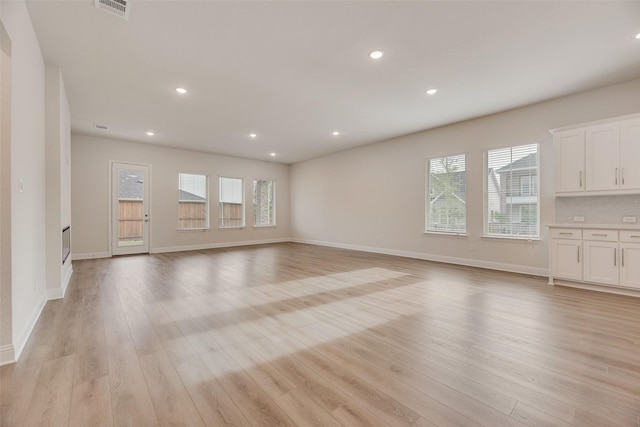 7104 Manhattan Dr, Rowlett, TX 75088 - unfurnished living room with plenty of natural light, light wood-style flooring, recessed lighting, and baseboards