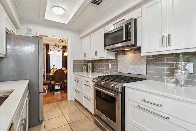4021 Tracey Trl, Rowlett, TX 75088 - kitchen featuring stainless steel appliances, white cabinetry, decorative backsplash, light stone countertops, and crown molding