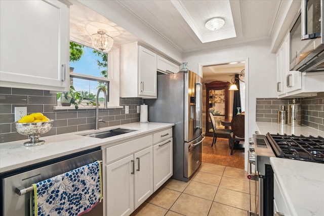4021 Tracey Trl, Rowlett, TX 75088 - kitchen featuring stainless steel appliances, a sink, white cabinets, ornamental molding, and backsplash