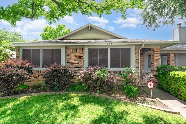 208 E Amberway Ln, Garland, TX 75040 - ranch-style house featuring a front yard, brick siding, a sunroom, and a chimney