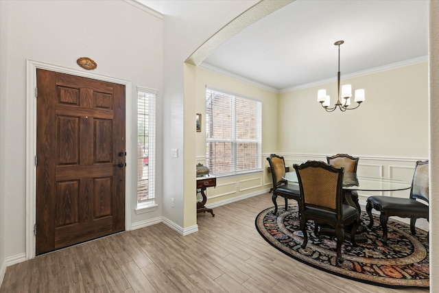 1032 Pinnacle Ridge Rd, Fort Worth, TX 76052 - entrance foyer featuring crown molding, a chandelier, arched walkways, wood finished floors, and a wainscoted wall