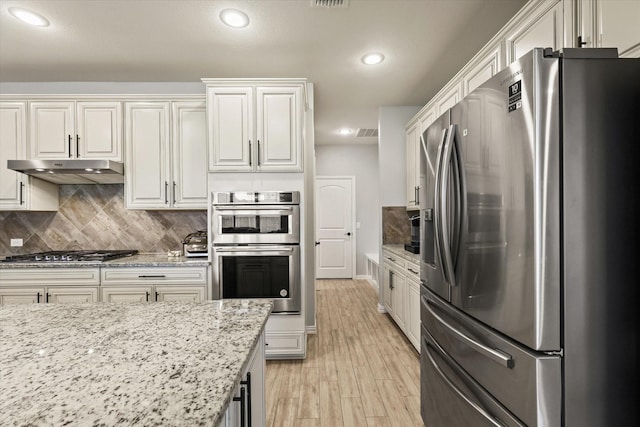 1032 Pinnacle Ridge Rd, Fort Worth, TX 76052 - kitchen featuring appliances with stainless steel finishes, under cabinet range hood, recessed lighting, tasteful backsplash, and light wood-style floors