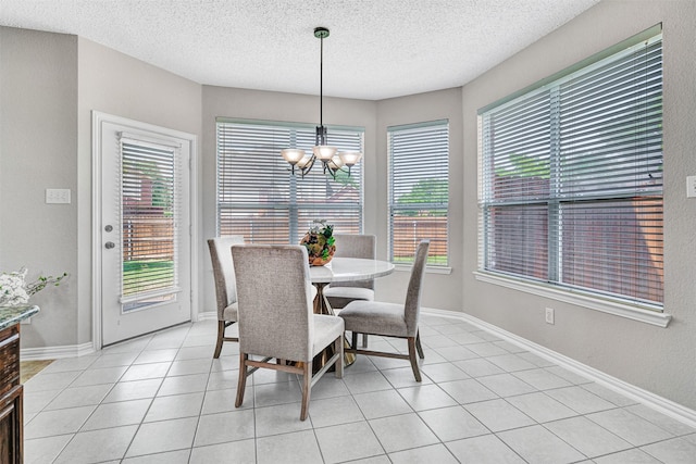 3501 Thorp Springs Dr, Plano, TX 75025 - dining area with a chandelier, a textured ceiling, light tile patterned floors, and baseboards
