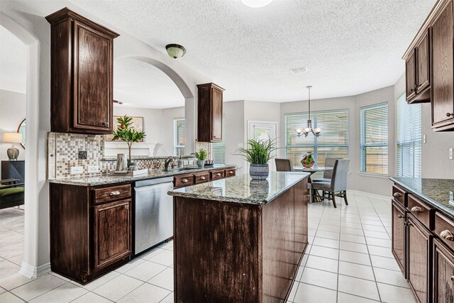 3501 Thorp Springs Dr, Plano, TX 75025 - kitchen with dishwasher, light tile patterned floors, a kitchen island, arched walkways, and a textured ceiling