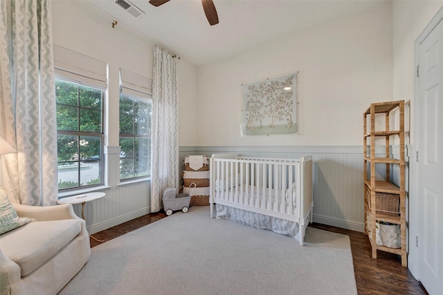 2307 Grizzly Run Ln, Euless, TX 76039 - bedroom featuring wood finished floors, wainscoting, a crib, and ceiling fan