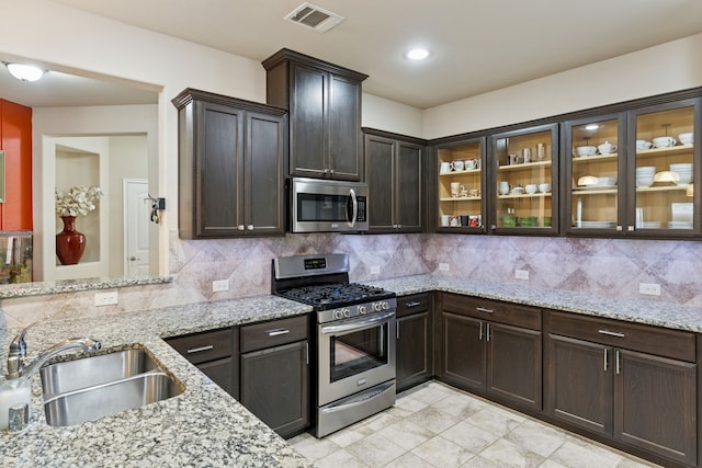 9812 Beaver Dam Ln, Mckinney, TX 75071 - kitchen featuring appliances with stainless steel finishes, a sink, tasteful backsplash, light stone counters, and recessed lighting