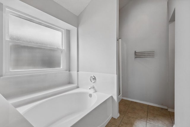 713 Bridle Trl, Saginaw, TX 76179 - full bathroom featuring a garden tub, baseboards, tile patterned flooring, and a shower stall