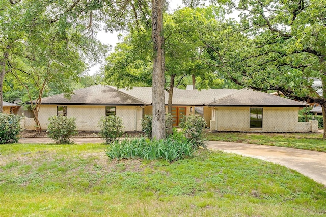 2317 Vega St, Grand Prairie, TX 75050 - view of front of house featuring concrete driveway, a front yard, and brick siding