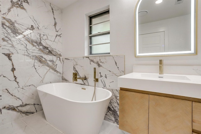 2317 Vega St, Grand Prairie, TX 75050 - bathroom featuring tile walls, vanity, a freestanding tub, and marble finish floors