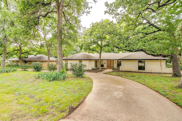 2317 Vega St, Grand Prairie, TX 75050 - view of front of house with concrete driveway, a front lawn, and brick siding