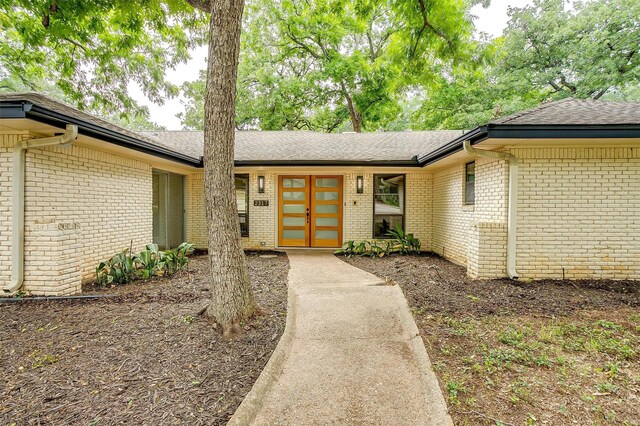 2317 Vega St, Grand Prairie, TX 75050 - doorway to property with brick siding and roof with shingles
