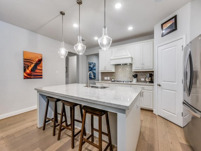 217 Fulton St, Oak Point, TX 75068 - kitchen featuring appliances with stainless steel finishes, custom exhaust hood, a sink, light wood-style flooring, and decorative backsplash