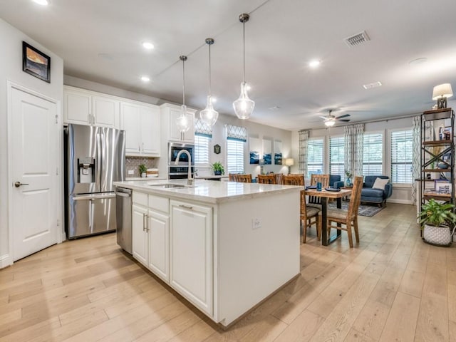 217 Fulton St, Oak Point, TX 75068 - kitchen featuring appliances with stainless steel finishes, a sink, light wood-type flooring, recessed lighting, and white cabinets