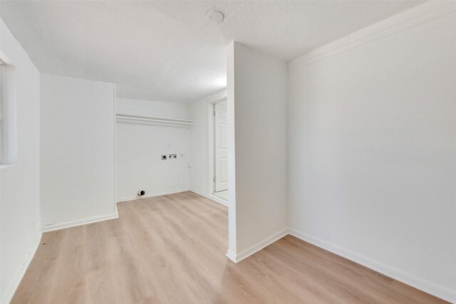 129 Western Ave, Saginaw, TX 76179 - laundry room with hookup for an electric dryer, light wood-style flooring, baseboards, hookup for a washing machine, and a textured ceiling